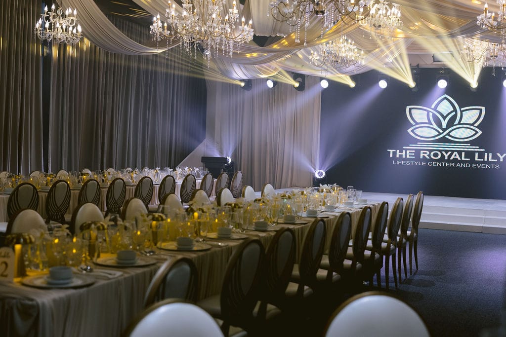 Long tables beside the LED wall and draping